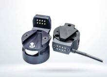 Schneider & Company - Two modern, black multi-pin connectors, one with its cover opened to reveal the metallic pins, against a clean, white background.